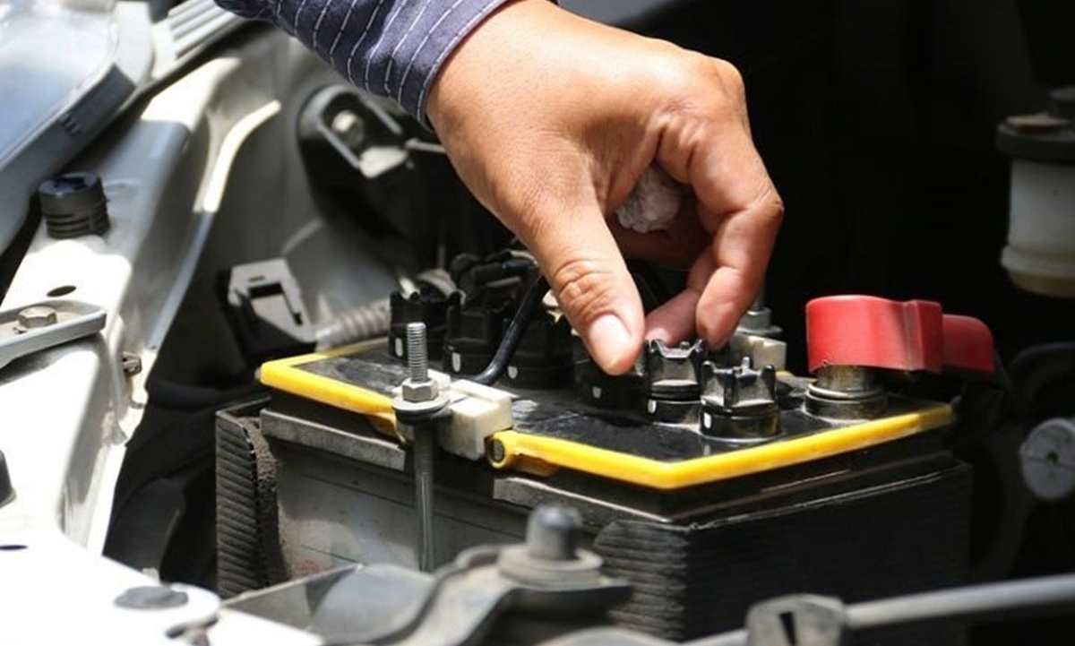 Hand adjusting car battery.