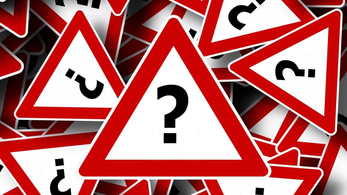 Question marks inside yield triangle warning signs.